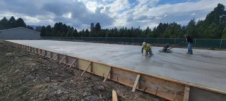 Poppoff crew edging and power troweling a fresh slab