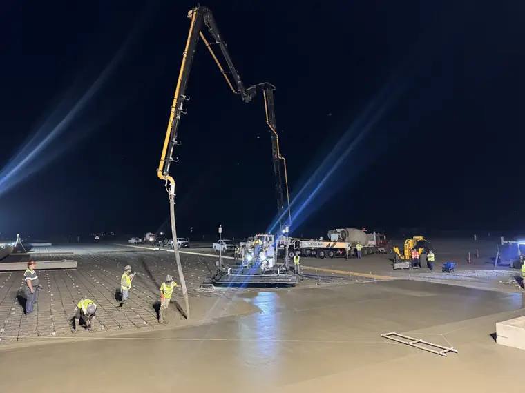 Night pour at the WinCo distribution site in Ellensburg, a Poppoff boom pump placing concrete ahead of the screed