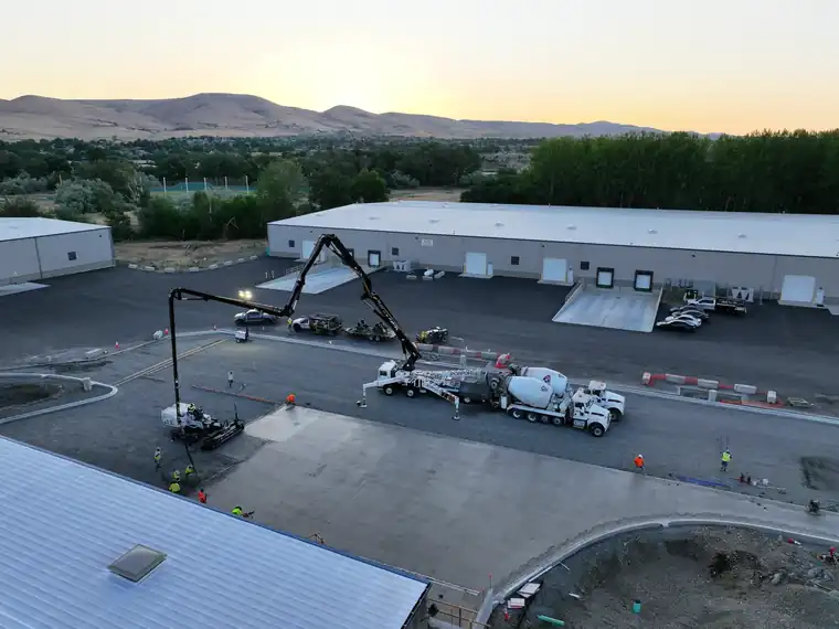 Aerial view at dusk of a Poppoff boom pump placing paving at the WWG2 site in Yakima