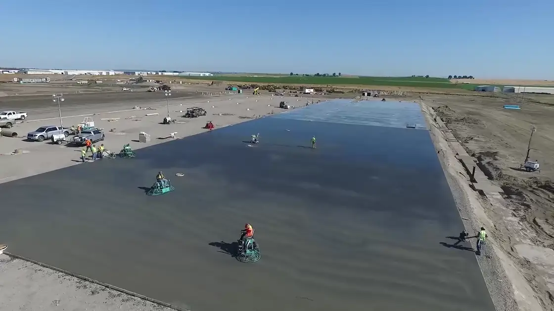 Aerial view of a Poppoff crew finishing a wide slab with ride-on trowels