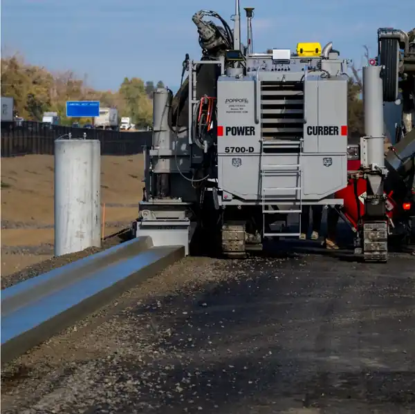 A Power Curber 5700-D extruding a continuous line of curb