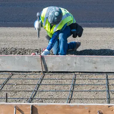 A Poppoff carpenter setting a form stake before a pour